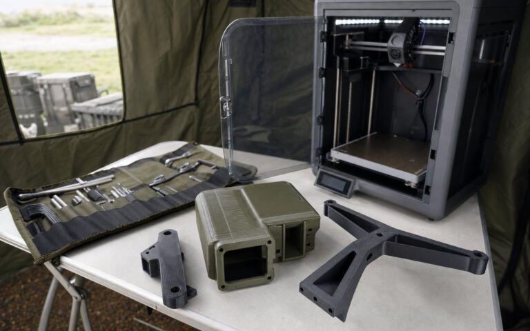 3D printed UAV brackets and a ruggedised radio housing on a field maintenance table